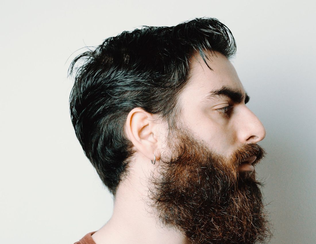 Profile of a client with a styled beard and blown-dry hair