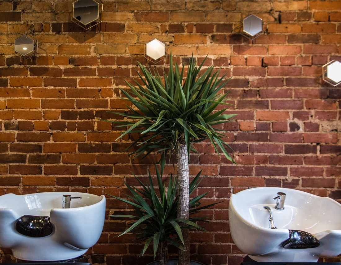 The wash basins at the back of the shop, against the brick