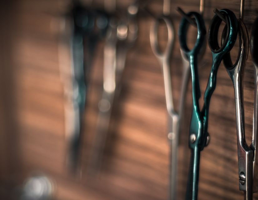 A pair of barber shears hanging against a blurred background
